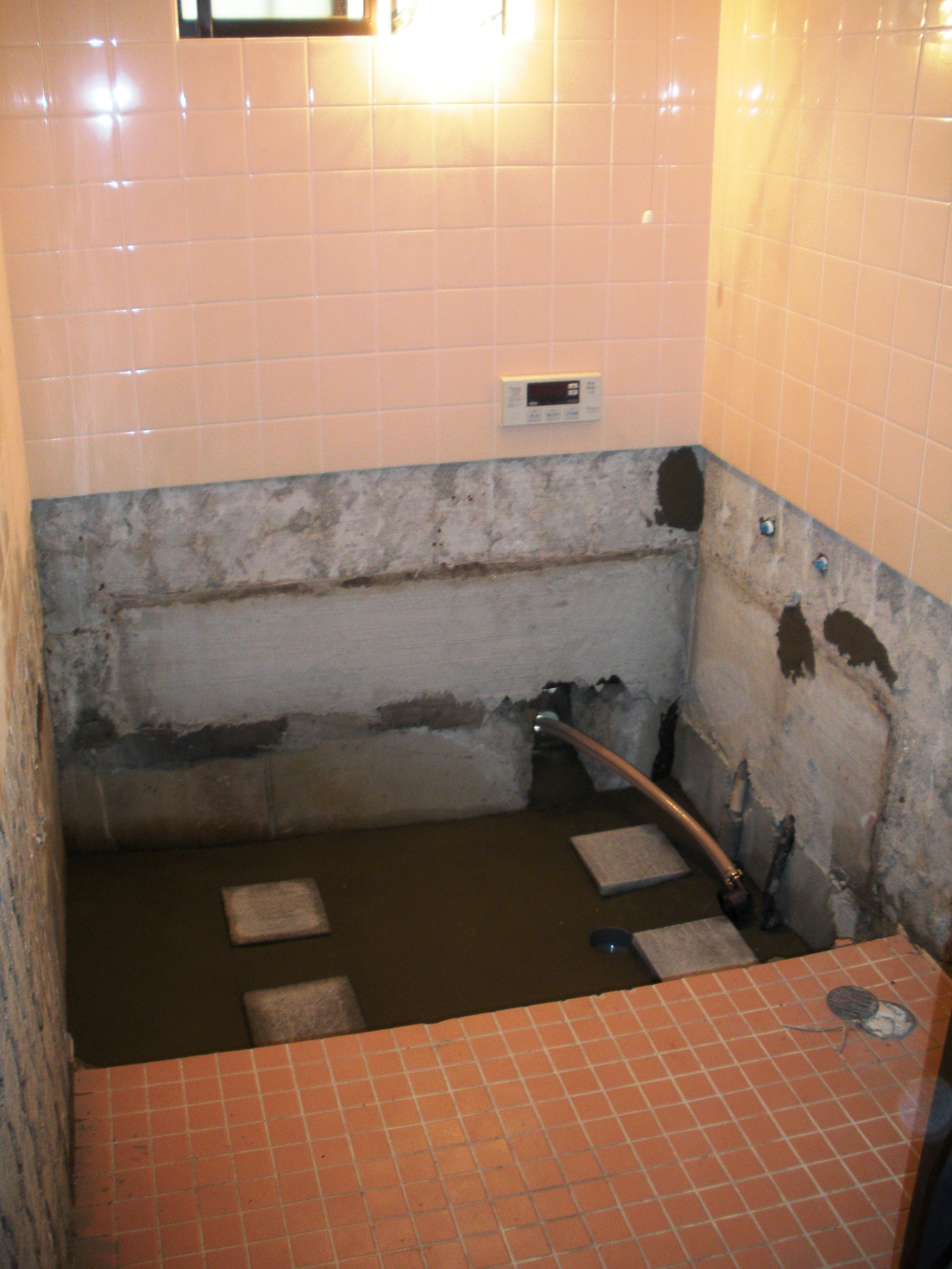 工事中：丁寧に解体をして浴槽下のレベルを合わせます。